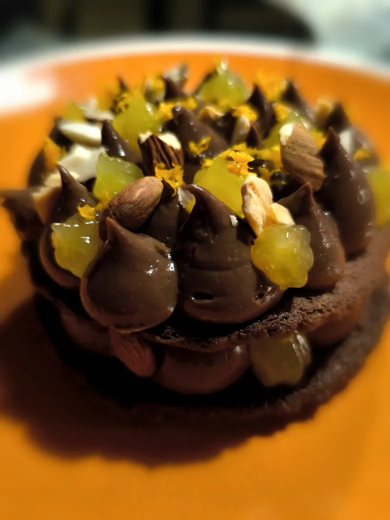 Monoporzione al cioccolato con ciuffi di ganache, mandorle e cubetti di gelatina